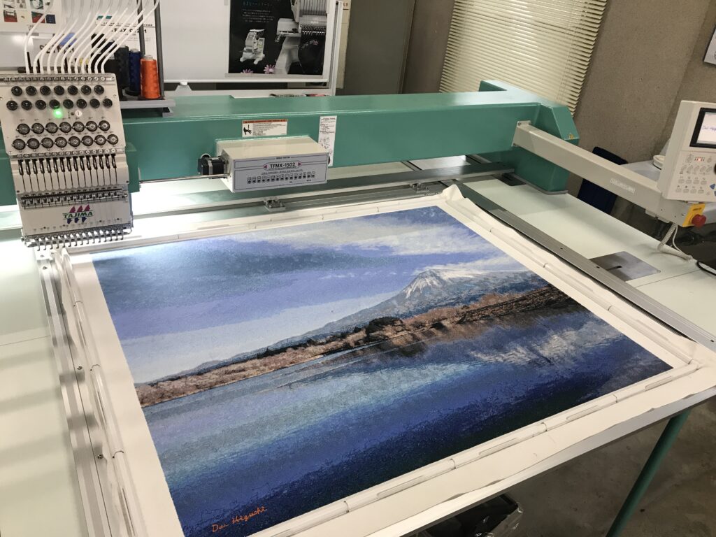 Photo embroidery art piece “Mt. Fuji as seen from Lake Tanuki” by Dai Higuchi. A panoramic view of the piece created using a Tajima embroidery machine.　　　　