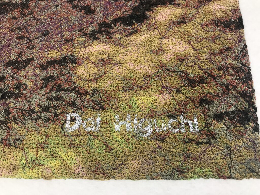 Close-up of the stitched signature “Dai Higuchi” at the bottom right of the photo embroidery artwork “Cherry Blossoms at Sewaritei.” The name stands out in white thread against a multicolored background.