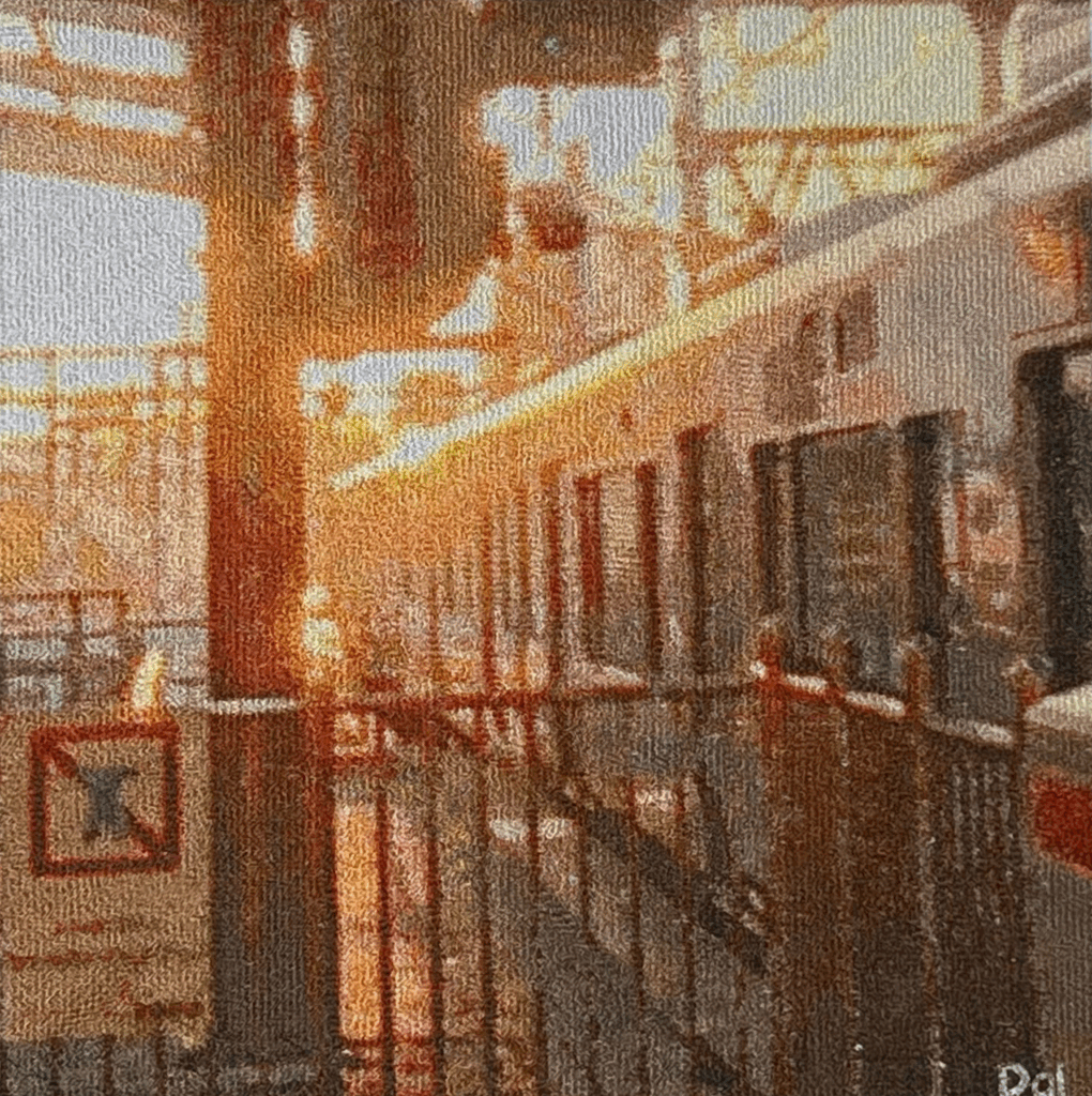 Photo embroidery artwork titled “The Way Home.” A train arriving at Osaka Station, bathed in the dazzling light of the setting sun, expressed through thread.