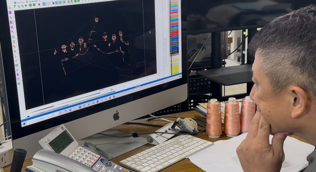 A photo embroidery artist carefully selecting thread colors while comparing the original image, embroidery data, and actual thread samples.