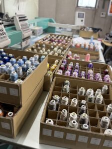 日本語： タジマ刺繍機と、フォト刺繍制作に使う数百色の刺繍糸。作品表現の幅を広げるための必須の環境。